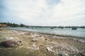 View on a sandy beach near to fishing village with a lot of garbage. Pollution of a coastline. Mui Ne Royalty Free Stock Photo