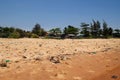 View on a sandy beach near to fishing village with a lot of garbage. Pollution of a coastline. Mui Ne, Vietnam Royalty Free Stock Photo