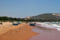 View on a sandy beach near to sea and fishing village with a lot of garbage. Pollution of a coastline. Royalty Free Stock Photo