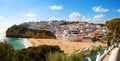 View of the sandy beach surrounded by typical white houses on a sunny spring day, Carvoeiro, Lagoa, Algarve, Portugal