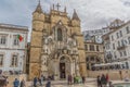 View of the Santa Cruz Monastery front facade, romanesque and gothic style, with tourists on street , a National Monument in