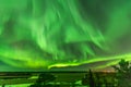 View from scandinavian hill to bright green aurora lights almost on the whole sky over tree tops in Sweden, river, clear skies Royalty Free Stock Photo