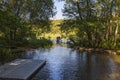 View of scandinavian river with several men on stand up paddle board.