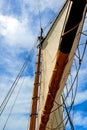 Schooner mast and sails against blue sky