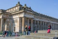 View of The Scottish National Gallery or National Gallery of Scotland, the neoclassical building, people interacting outside