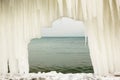 View of the sea through an arch from icicles on a moody day Royalty Free Stock Photo