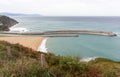 View of the sea and coast with lighthouse. Biscayne bay with scenic coastline. Basque country landscape. Breakwater stones.