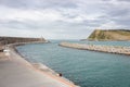View of the sea and coast with lighthouse. Biscayne bay with scenic coastline. Basque country landscape. Breakwater stones.