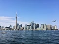 A view of the sea front at Toronto from a boat with a plane coming in to land