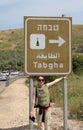 Woman pilgrim above Tabgha sign. On the road to The Church of Multiplication of loaves and fish in Tabgha, Israel. Pilgrimage