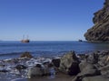 View on sea horizon with old Sailing ship from black sand beach Playa De Masca