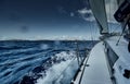 The view of the sea and mountains from the sailboat, edge of a board of the boat, slings and ropes, splashes from under