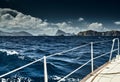 The view of the sea and mountains from the sailboat, edge of a board of the boat, slings and ropes, splashes from under