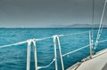 The view of the sea and mountains from the sailboat, edge of a board of the boat, slings and ropes, splashes from under