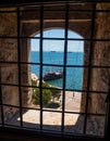 View of the sea and the ships through the bars on the window in the White Tower in Thessaloniki, Greece Royalty Free Stock Photo