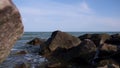 View of the sea surface due to large stones, camera moving forward, summer day