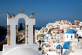 View of sea surface through traditional Greek white church arch with cross and bells in Oia village of Cyclades Island, Santorini, Royalty Free Stock Photo