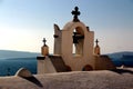 View of sea surface through traditional Greek white church arch with cross and bells in Oia village of Cyclades Island, Santorini, Royalty Free Stock Photo