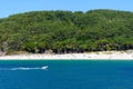 View from the sea to the beach and pleople on the sand on a sunny day