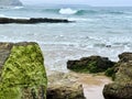 View of the sea waves coming ashore on the rocky beach at low tide in a beach landscape Royalty Free Stock Photo