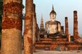 View of a seated Buddha statue among ruined columns in Wat Mahathat, an ancient Buddhist temple in Sukhothai Historical Park Royalty Free Stock Photo