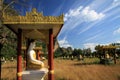 View on secluded valley with over 1000 sitting buddha statues in rows contrasting with blue sky