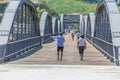 View of a senior couple of tourists on backs, strolling through the metallic bridge of the city of Peso Regua