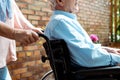 View of senior disabled man sitting in wheelchair near wife Royalty Free Stock Photo