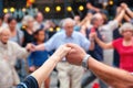 View of senior people holding hands and dancing national dance Sardana