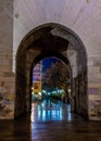 View through Serrano Towers (Torres de Serranos) at night. Towers are located on Plaza de los Fueros in Valencia