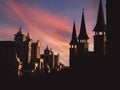 View of several black silhouettes of historic palace towers against a sunset orange sky and a sunbeam Royalty Free Stock Photo