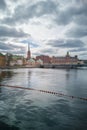 View of several historic building behind river in old Stockholm town. Place of oldest Swedish book publishing company - Norstedts