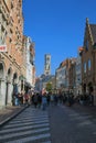 View on shopping street with people and church tower background, clear blue sky