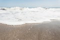 View from the shore on a hectic ocean with white foam with waves with clear blue sky in a sunny summer day. Beautiful seascape.