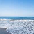 View of from the shore of on a restless sea with of white foam with sunny sky. Summer paradise beach in Spain. Summer seascape. Royalty Free Stock Photo