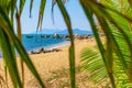 View of the shore of the South China Sea with a sandy beach, large rocks and green palm trees. Sanya, China. Royalty Free Stock Photo