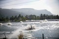 view of shrimp farm with rotating water wheel, mountains background, tambak udang.