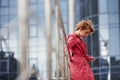 View from the side. Adult pretty woman in warm red coat have walk in the city at her weekends time Royalty Free Stock Photo