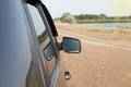 View of the side of the car standing against the background of the autumn landscape, the rearview mirror of the vehicle Royalty Free Stock Photo