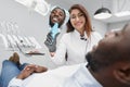 Dentist keeping mirror and showing white smile to patient Royalty Free Stock Photo