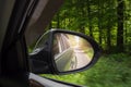 A view in the side view mirror. Mirror rear car. Reflection of the road Royalty Free Stock Photo