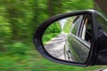 A view in the side view mirror. Mirror rear car. Reflection of the road Royalty Free Stock Photo