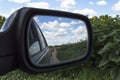A view in the side view mirror. Reflection of the country road Royalty Free Stock Photo