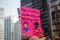 View of sign How is covering shoulders more important than wearing a mask taken during Vancouver rally for mandatory masks in