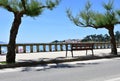 View of Silgar Beach from promenade with stone handrail and wooden bench. Rias Baixas, Pontevedra Province. Sanxenxo, Spain. Royalty Free Stock Photo