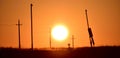 View of the silhouettes of electricity poles during sunset