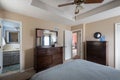 View of a simple decorated home bedroom wooden interior with carpet-covered floor