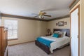 View of a simply decorated home bedroom interior with carpet-covered floor