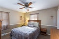 View of a simply decorated home bedroom wooden interior with carpet-covered floor