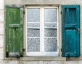 Single window with old blue and green wooden shutters Royalty Free Stock Photo